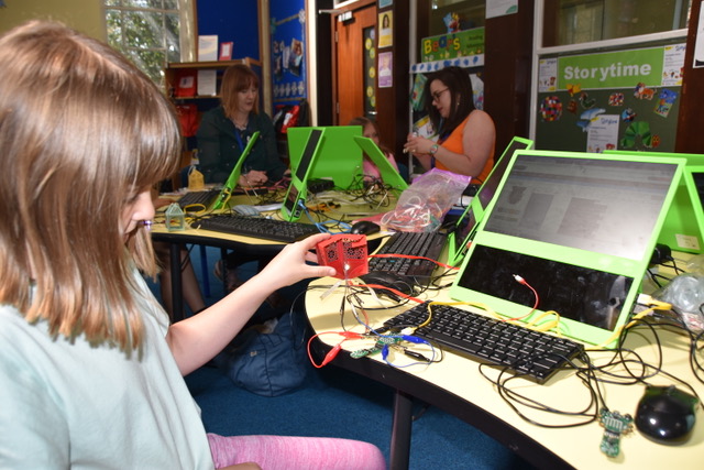 girl shows LED displaying temperature data from a raspberry pi iot project