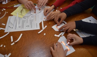 4 pairs of hands creating paper circuits