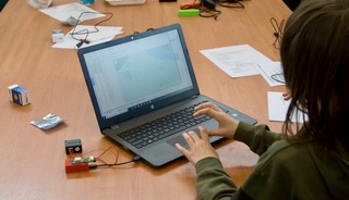 child 2 looking at laptop screen showing mapping of air quality data