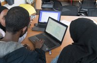 children and adults family group looking at laptop screen showing mapping of air quality data