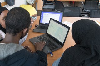 children and adults family group looking at laptop screen showing mapping of air quality data