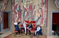 4 girls sat on a chair in front of a tapestry in a room at bolsover castle