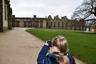 girl taking photograph of castle
