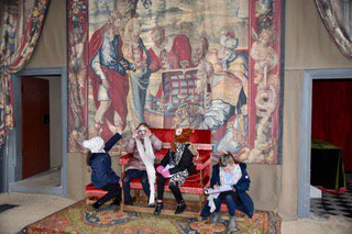 4 girls sat on a chair in front of a tapestry in a room at bolsover castle